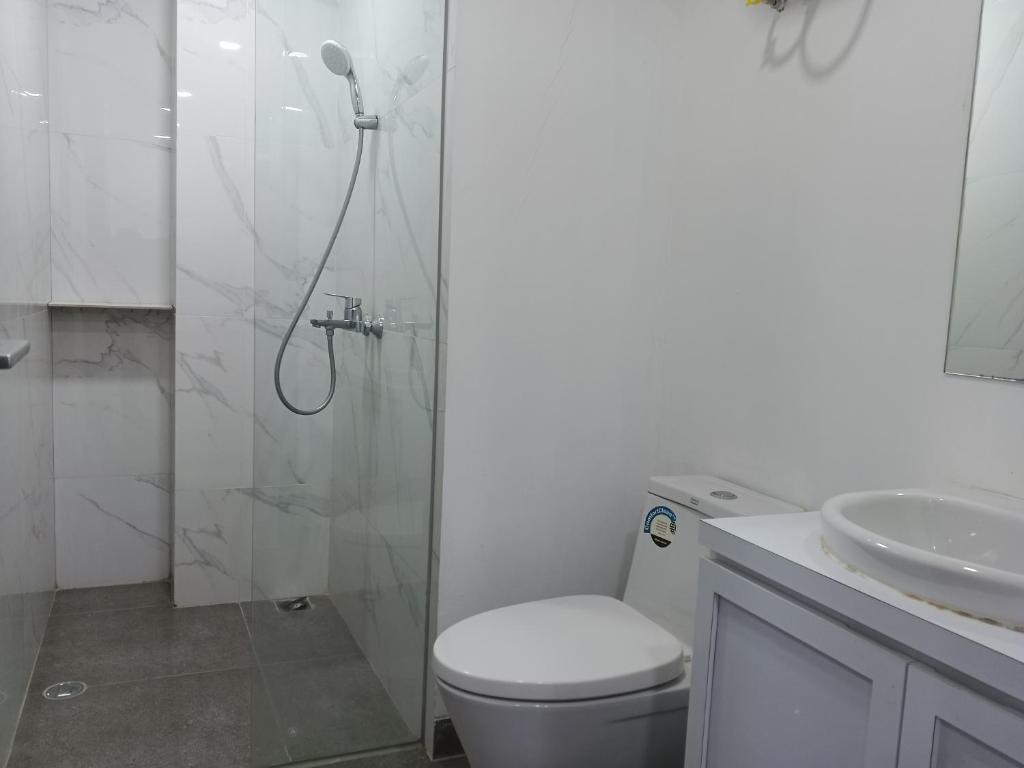 a bathroom with a shower and a toilet and a sink at Peaceful Sea view Cozy APT at Batam Center - By MESA in Batam Center