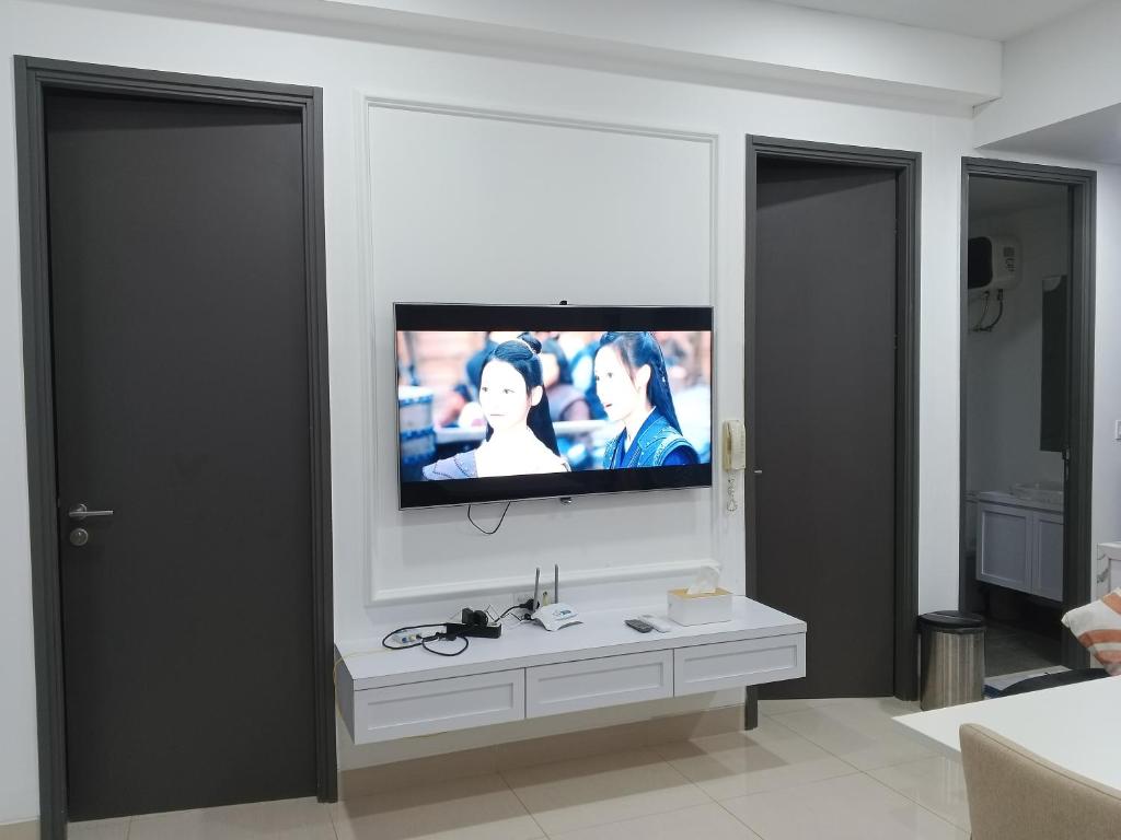 a living room with a television on a wall at Peaceful Sea view Cozy APT at Batam Center - By MESA in Batam Center