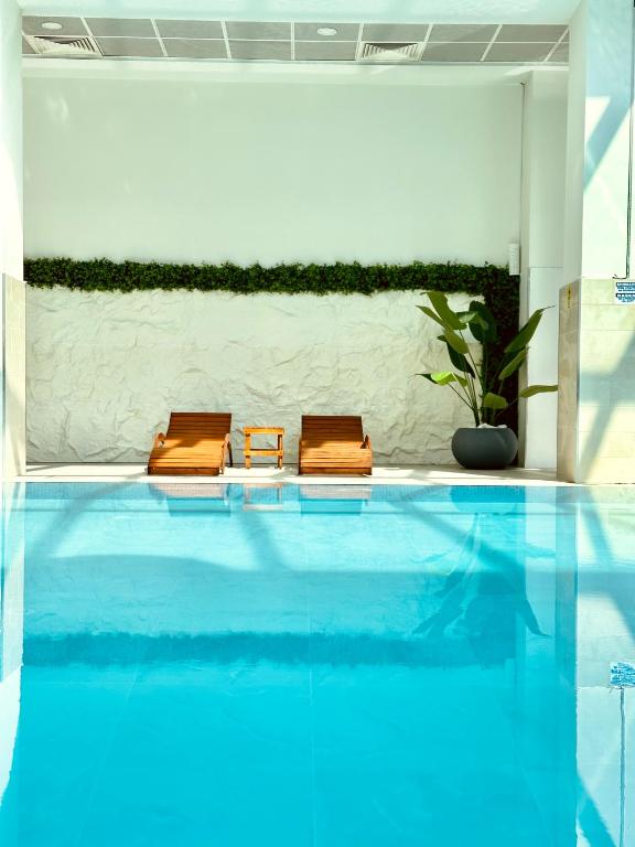 two brown chairs sitting next to a swimming pool at Royal Kate SPA included, 32nd floor in Skopje