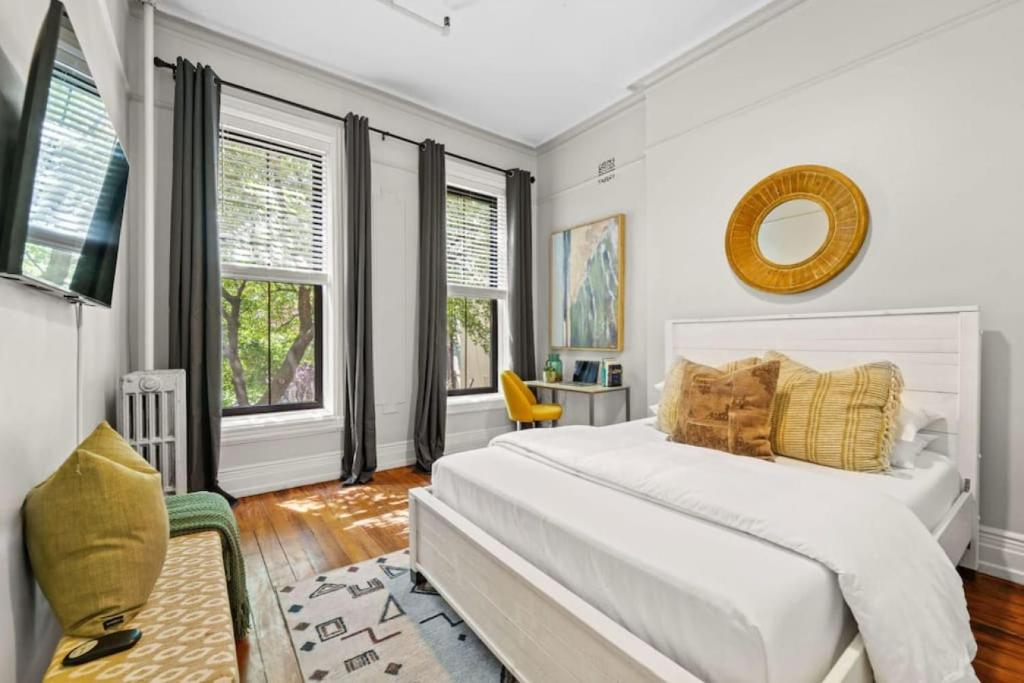 a white bedroom with a large bed and windows at 3BR Retreat Walkable to Columbia University in New York