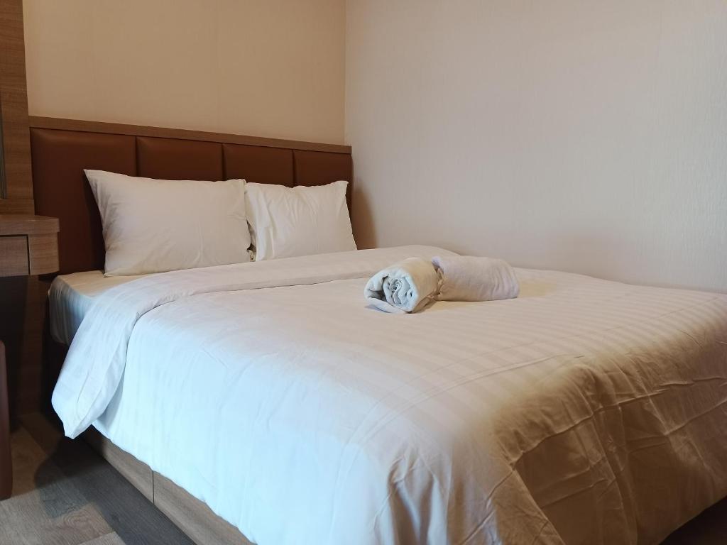 a white bed with a towel on top of it at Peaceful Sea view Cozy APT at Batam Center - By MESA in Batam Center