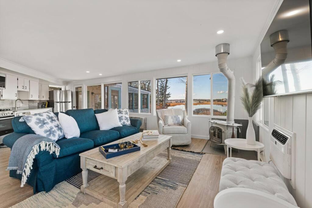 uma sala de estar com um sofá azul e uma mesa em Waterfront Newly Renovated w Amazing Views em Oak Bluffs