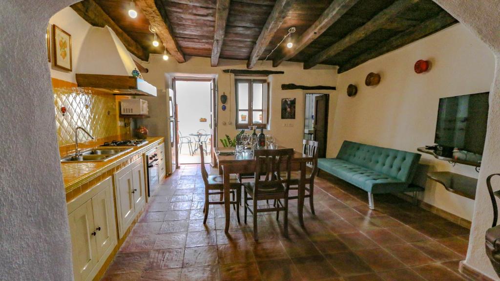 - une cuisine et une salle à manger avec une table et un canapé dans l'établissement Casa Clara, à Mamoiada