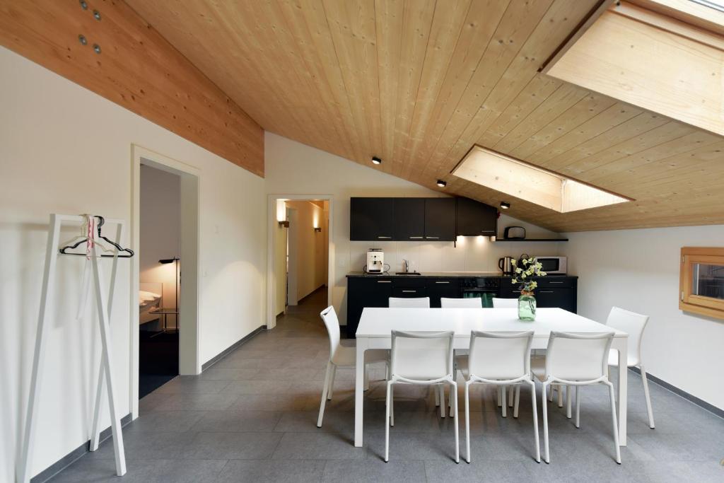 a kitchen and dining room with a white table and chairs at Luna Elk Home in Lenk