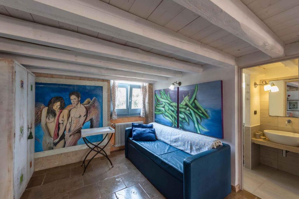 un soggiorno con divano blu e lavandino di Apartments in Spongano/Apulien 20947 a Spongano