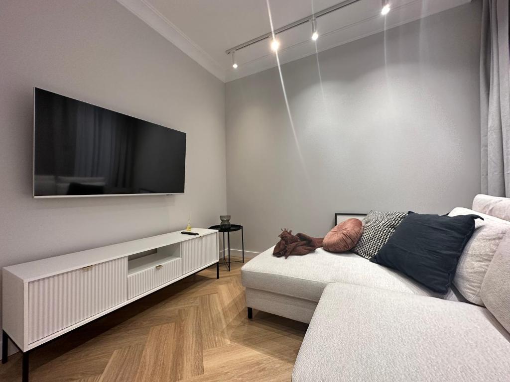 a living room with a couch and a flat screen tv at Odrzańska 17B Apartment - Self Check-In 20h in Wrocław