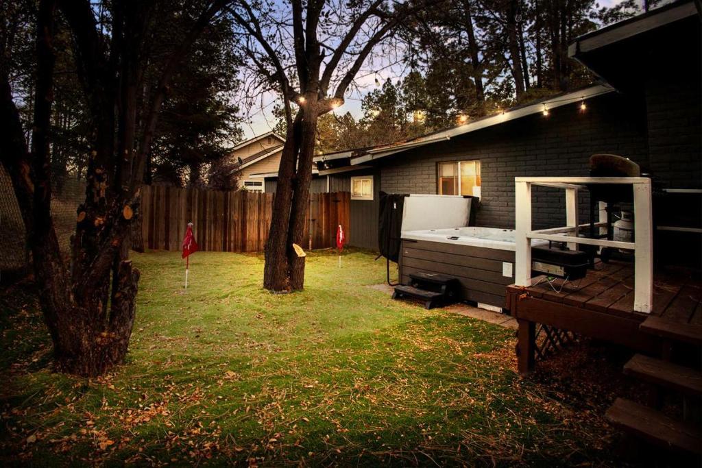 a backyard with a bed and a tree and a house at Modern Boho - Hot Tub - 9 min to Downtown in Flagstaff