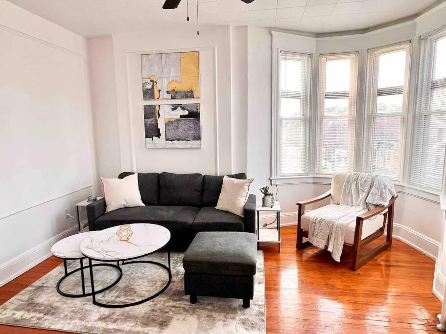 a living room with a black couch and a table at Bright, Stunning Downtown Apt, Close to Proctors in Schenectady