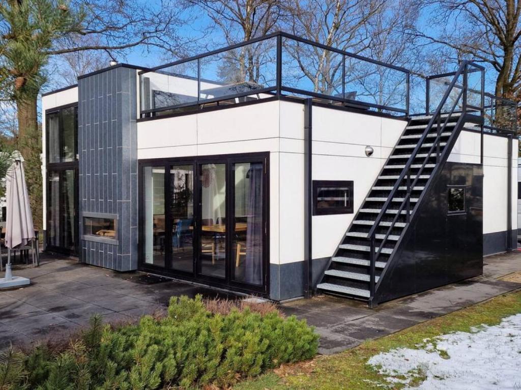 een zwart-wit huis met een wenteltrap bij Holiday Home Maridu Forest Cube in Arnhem