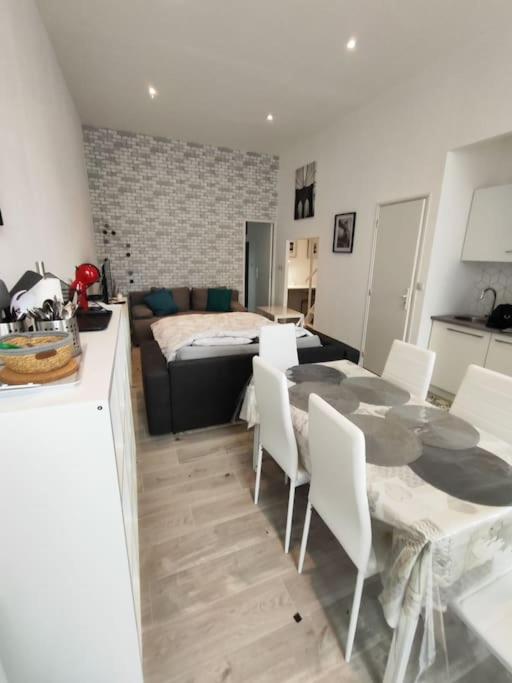 un salon avec une table et des chaises blanches dans l'établissement Grand volume calme centre-ville Tan1, à Cambrai