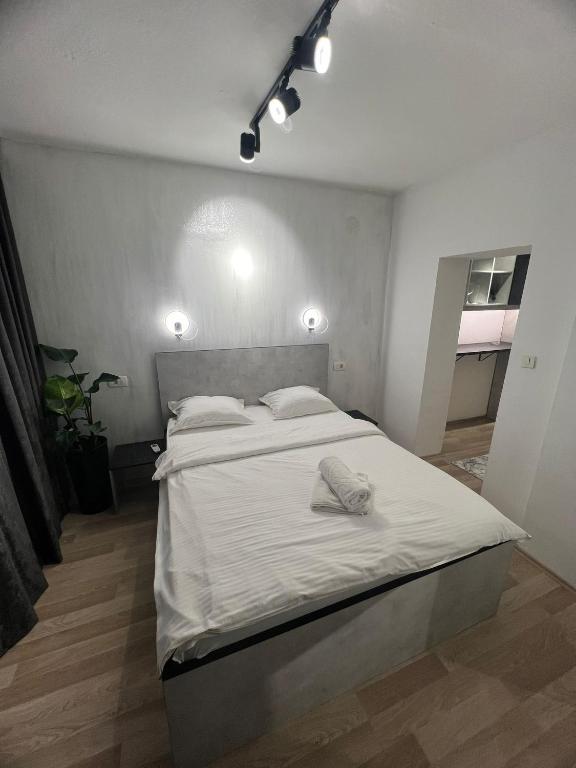 um quarto com uma cama grande e lençóis brancos em MT Center Square em Skopje