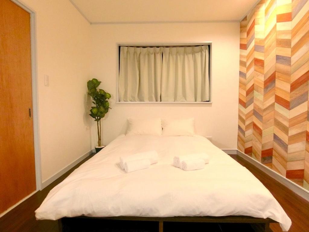 a large white bed in a room with a window at futaba heights - Vacation STAY 15532 in Tokyo