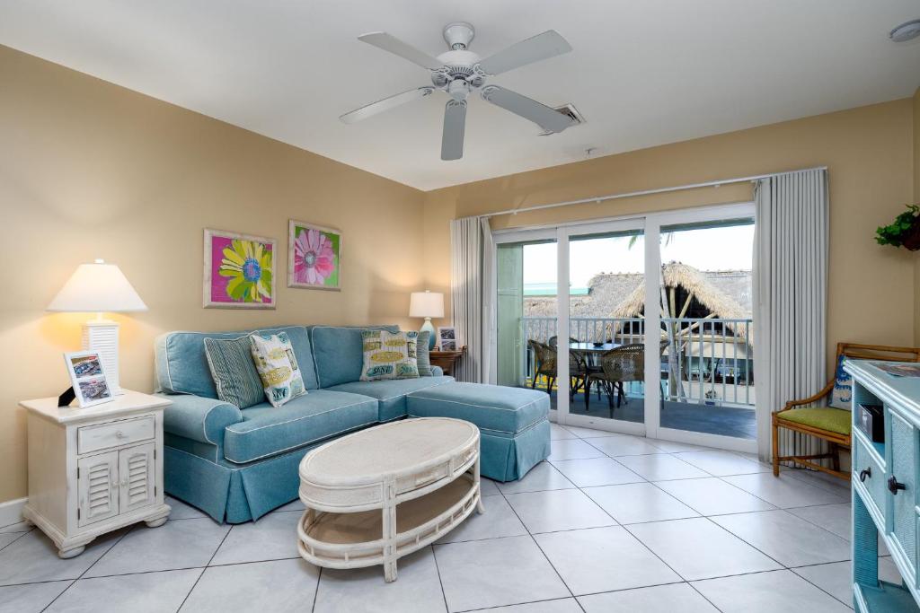 a living room with a blue couch and a table at Harbour House at the Inn 204 in Fort Myers Beach