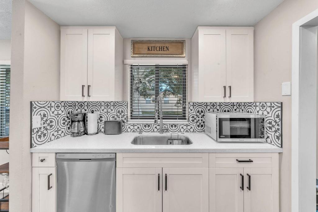 - une cuisine blanche avec évier et four micro-ondes dans l'établissement Coconut Bungalow - Modern 3 1 in Grove Bay, à Miami