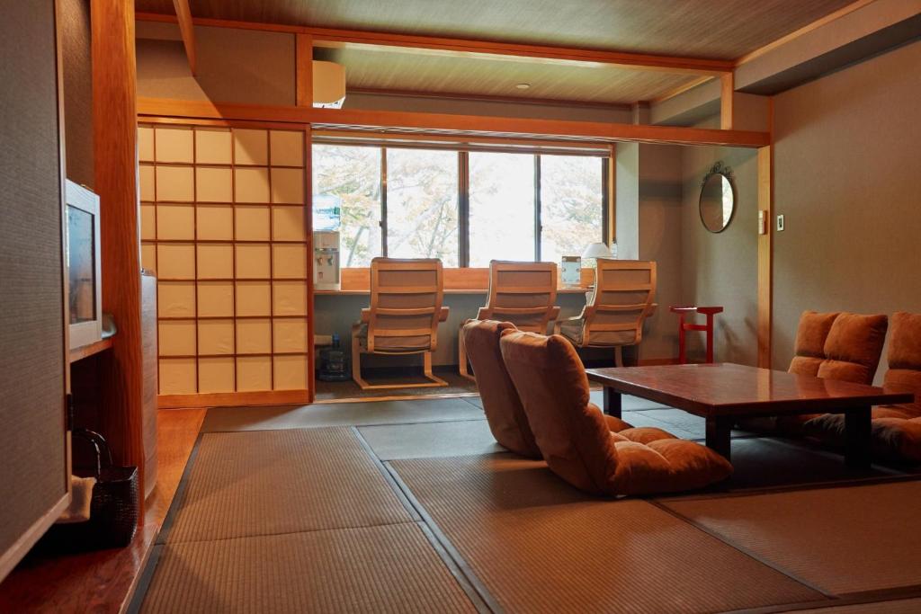 um quarto com cadeiras e uma mesa e uma mesa e cadeiras em Towadakohan Sakura - Vacation STAY 03811v em Towada