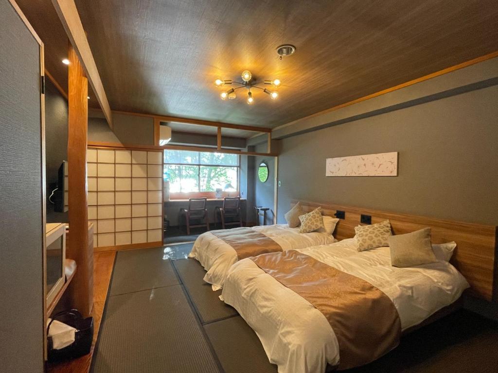 a bedroom with two beds and a ceiling at Towadakohan Sakura - Vacation STAY 80357v in Towada