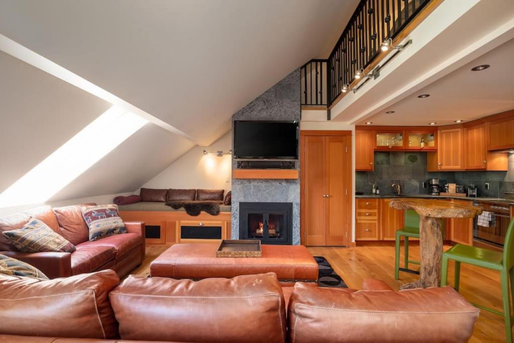 Una sala de estar con muebles de cuero y chimenea. en The Ikon Lofted Studio with King Bed and Patio, en Whistler