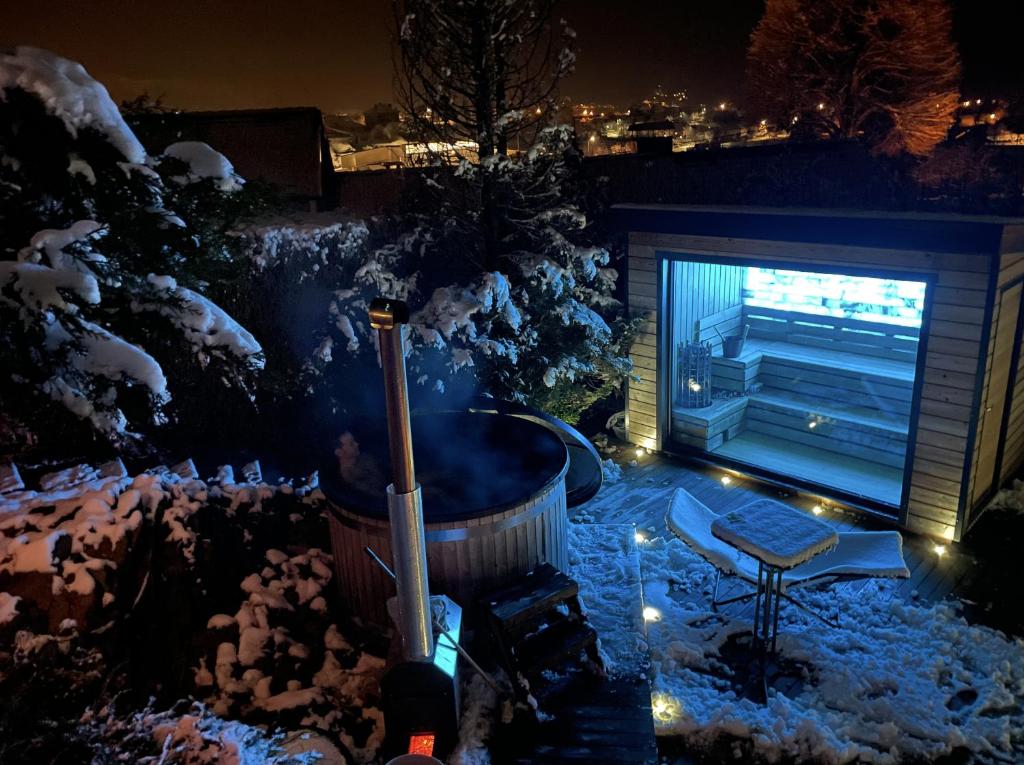 a snow covered backyard with a hot tub and a television at L'ANNEXE in Saint-Étienne-lès-Remiremont