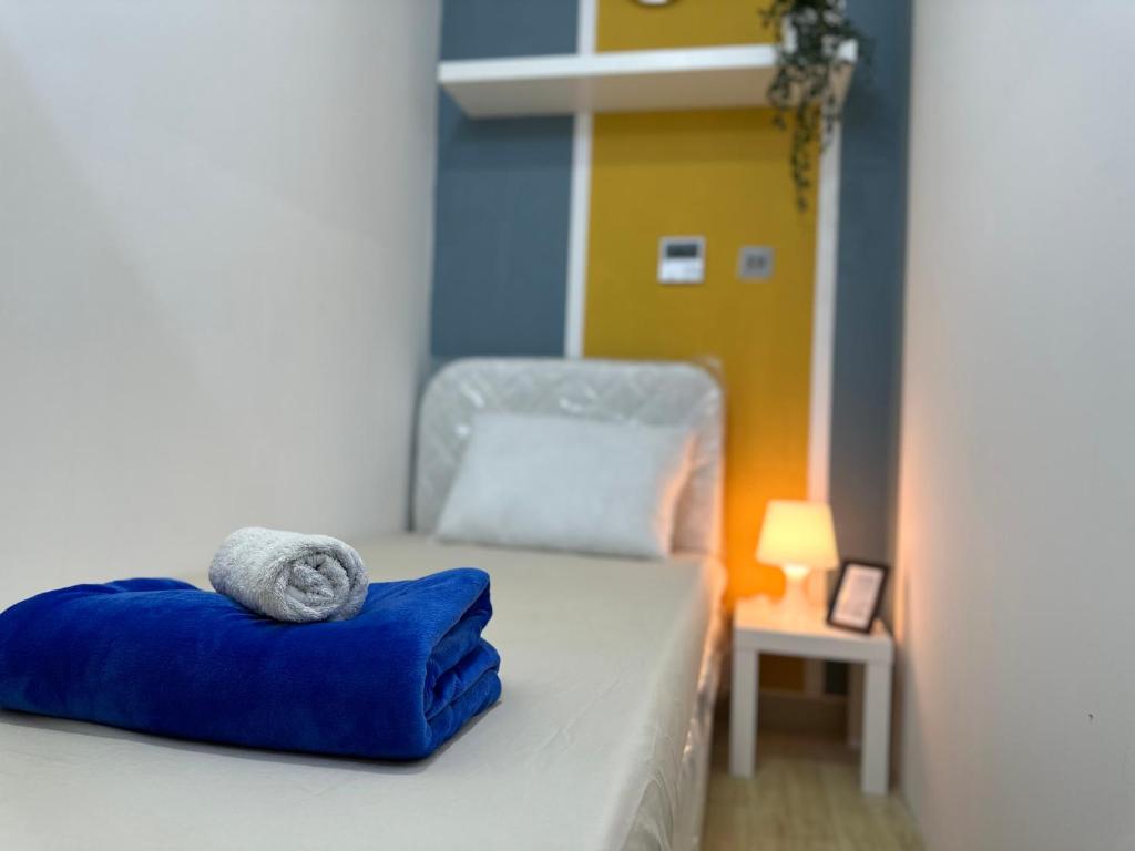 Un dormitorio con una cama con almohadas azules y una silla en Lovely Partition Room in Barsha 1 Near Metro en Dubái