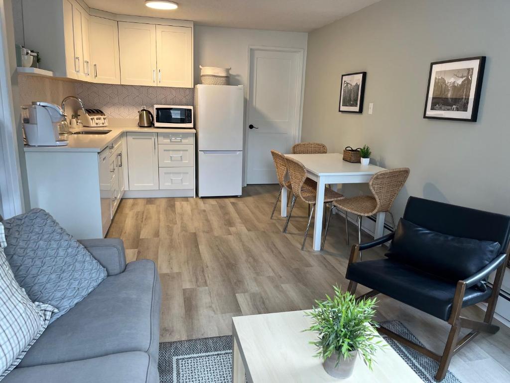 a living room with a couch and a table and a kitchen at Mountain View Bed & Breakfast in Banff