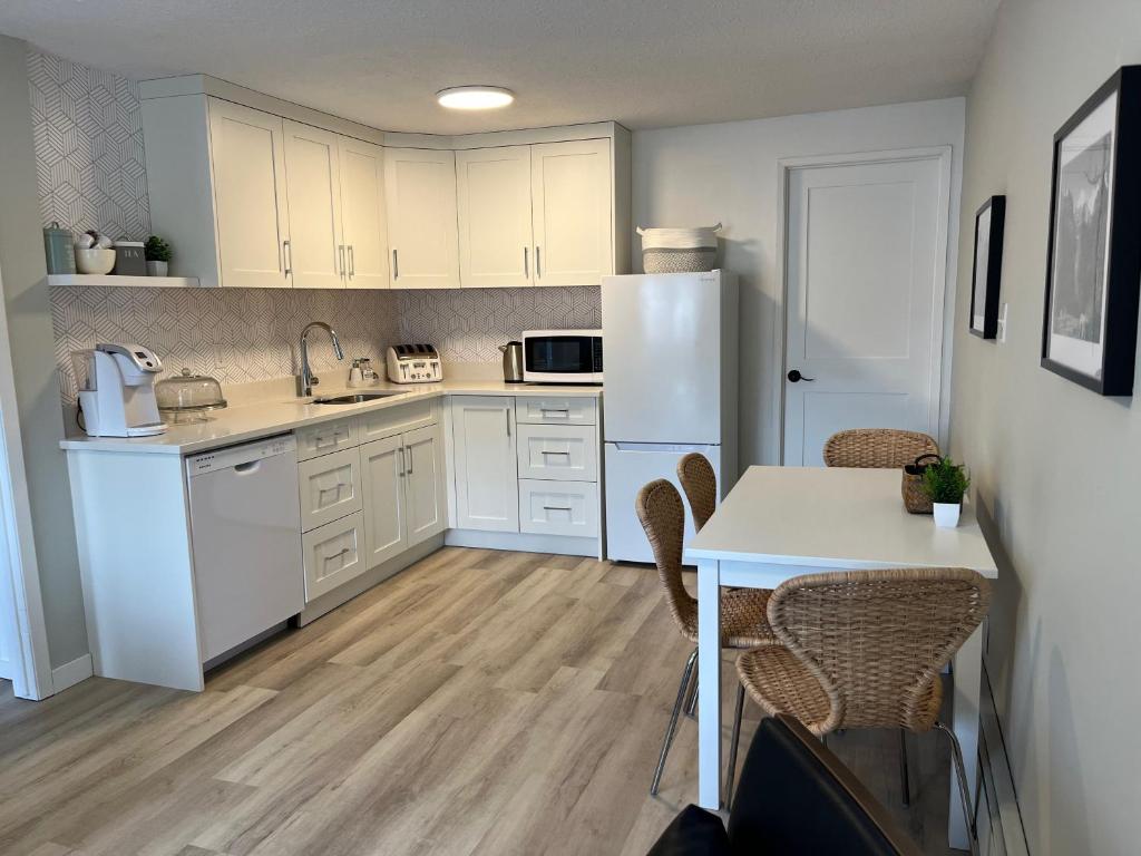 a kitchen with white cabinets and a table with chairs at Mountain View Bed & Breakfast in Banff