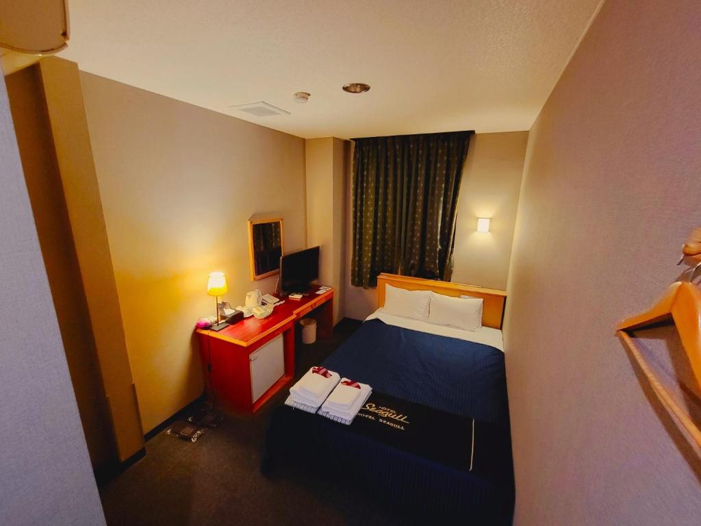 a hotel room with a bed and a desk with a computer at HOTEL SEAGULL - Vacation STAY 86804v in Izumi-Sano