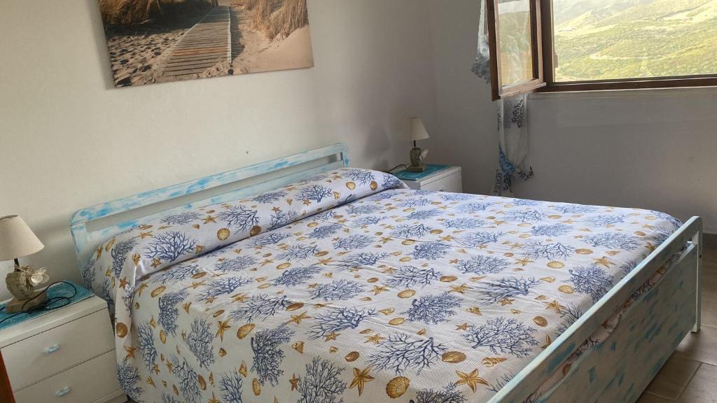 1 dormitorio con cama con edredón en Domo Mea, en Miniera dellʼArgentiera