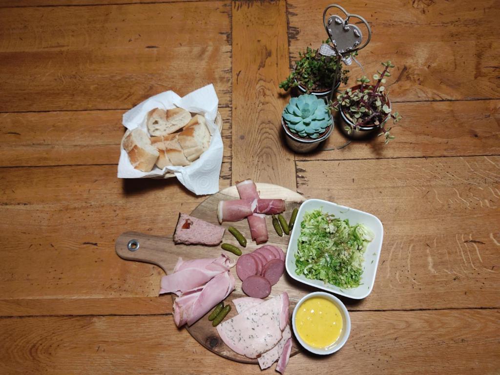 a wooden table with a cutting board with food on it at Au pied de la colline in Alembon