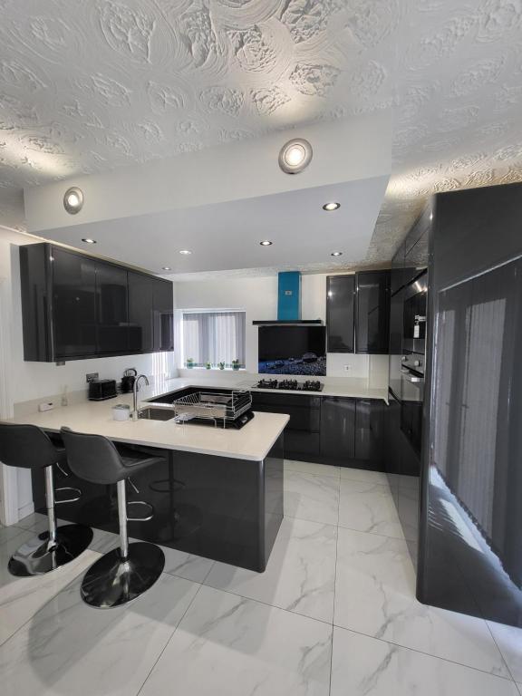 曼徹斯特的住宿－Serene 3BR home with free parking，厨房配有白色的柜台和黑色的橱柜。