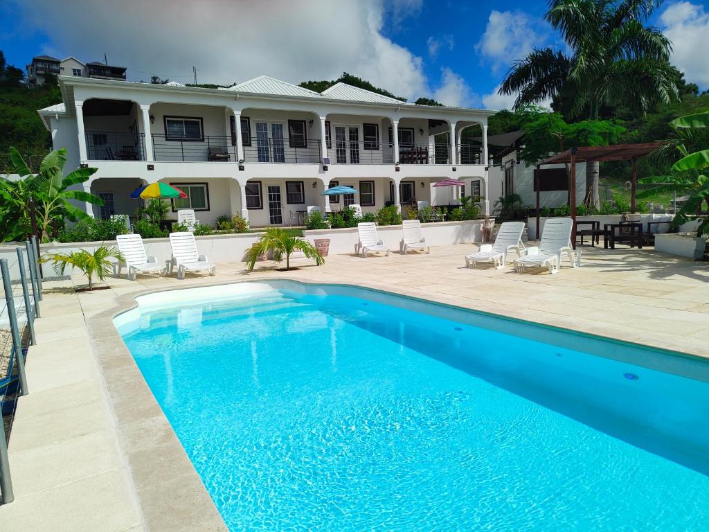 a swimming pool in front of a house at Holiday Home Belvedere in Dickenson Bay