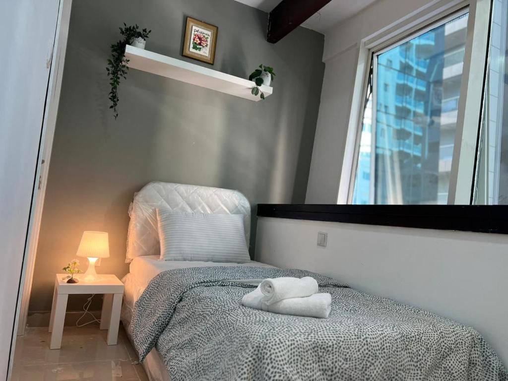 um pequeno quarto com uma cama e uma janela em Partition Room With Window Near MOE Metro em Dubai