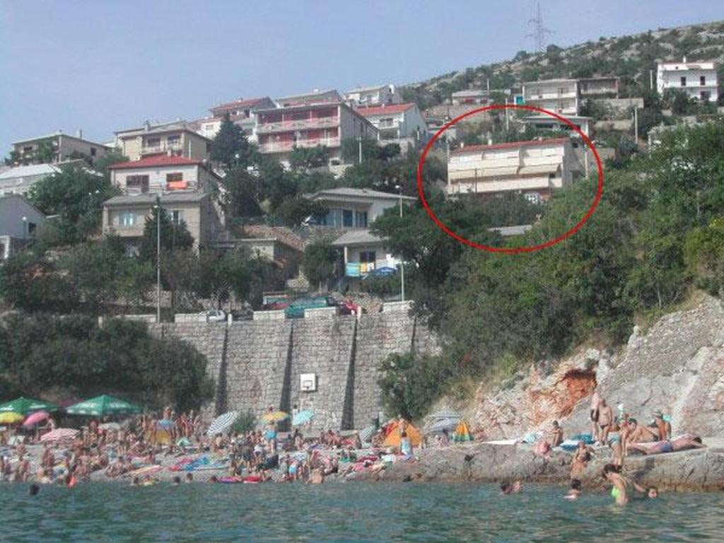 a group of people on a beach near the water at Apartments Bobinac in Senj