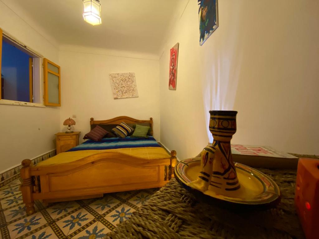 a bedroom with a bed and a table in it at Mask Off Artel in Essaouira