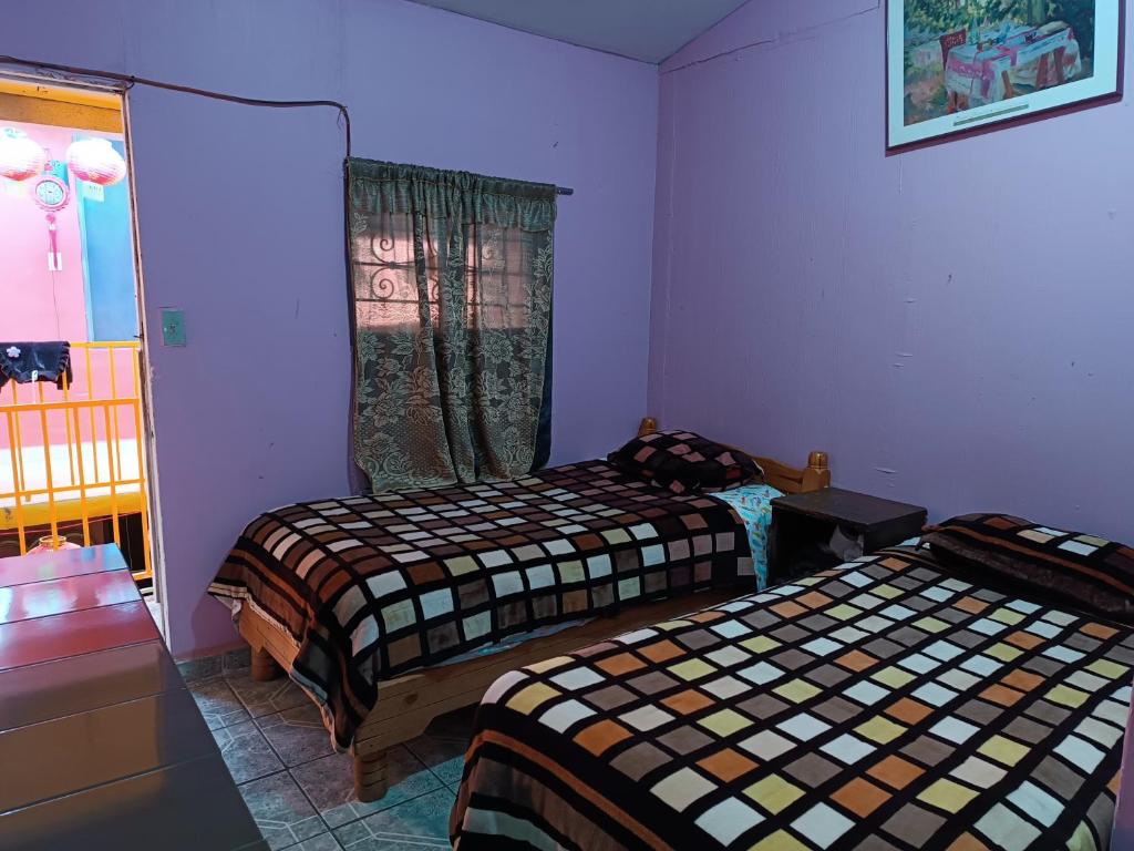 a room with two beds and a window in it at Hospedaje Barato Mi Casita de Colores in Tijuana