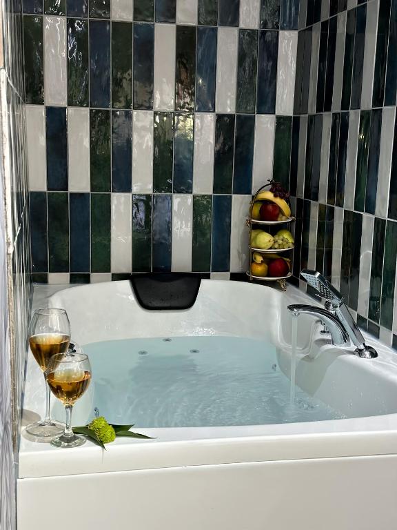 a bath tub with a glass of wine and a glass of wine at Dem Premium Hotel - Round Trip Airport Service - Istanbul International Airport in Arnavutköy