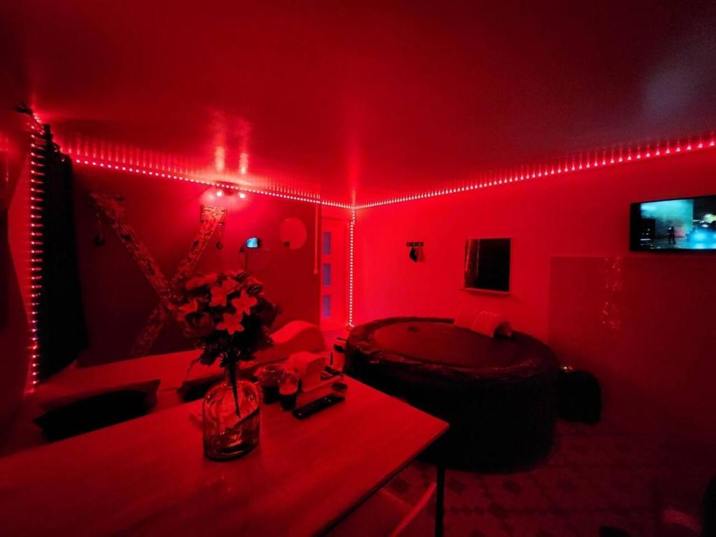 una habitación roja con una mesa con flores. en Studio cosy entre amoureux, en Verneuil d'Avre et d'Iton