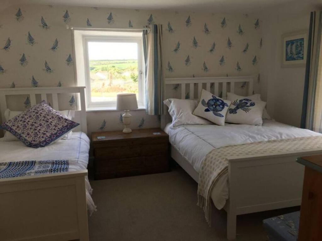 1 Schlafzimmer mit 2 Betten und einem Fenster in der Unterkunft Sandown, St Teath 3 bed sleeps 6 in Saint Teath