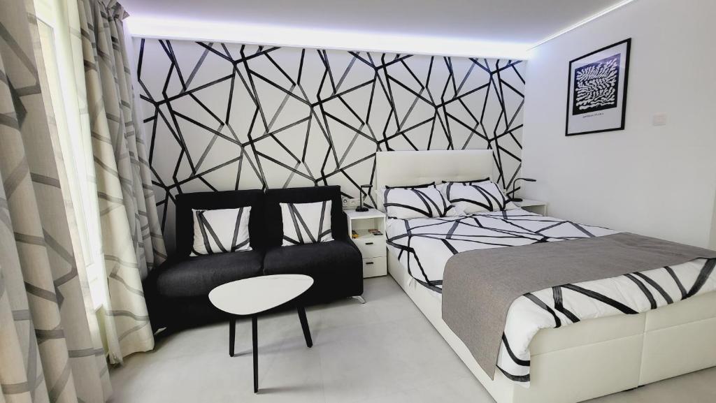 una camera da letto in bianco e nero con un letto e una sedia di THE STUDIO a Ostenda
