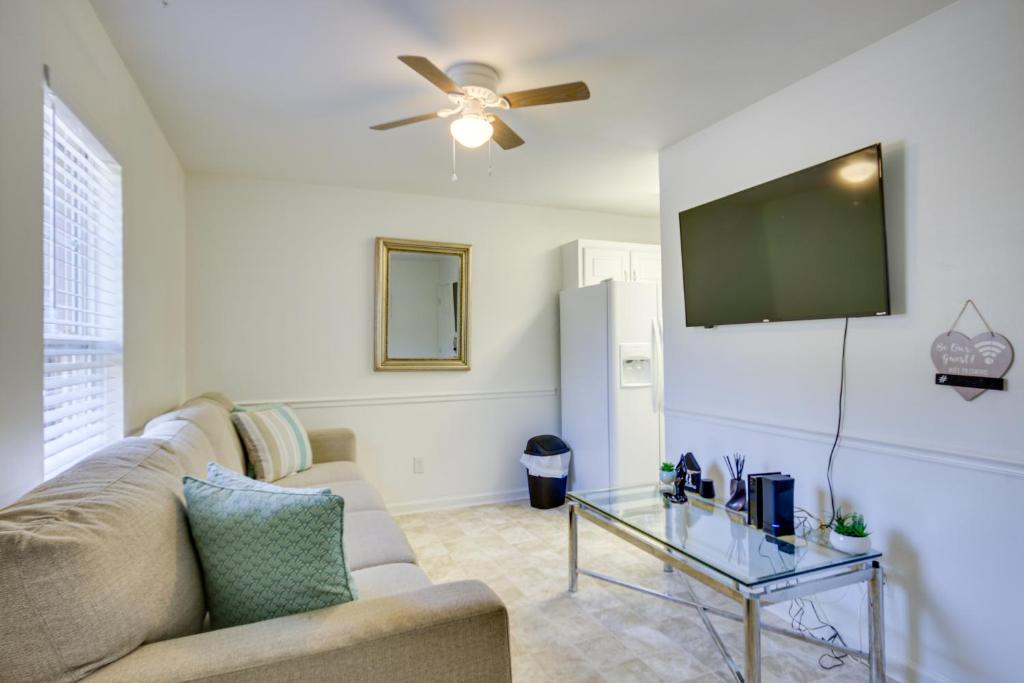 a living room with a couch and a flat screen tv at Quaint Orangeburg Townhome Near Hospitals and Campus in Orangeburg