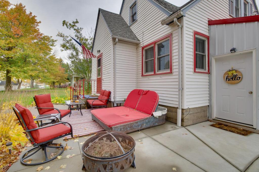 a patio with red chairs and a house at Harmony Home with Fire Pit 5 Mi to Niagara Cave! 