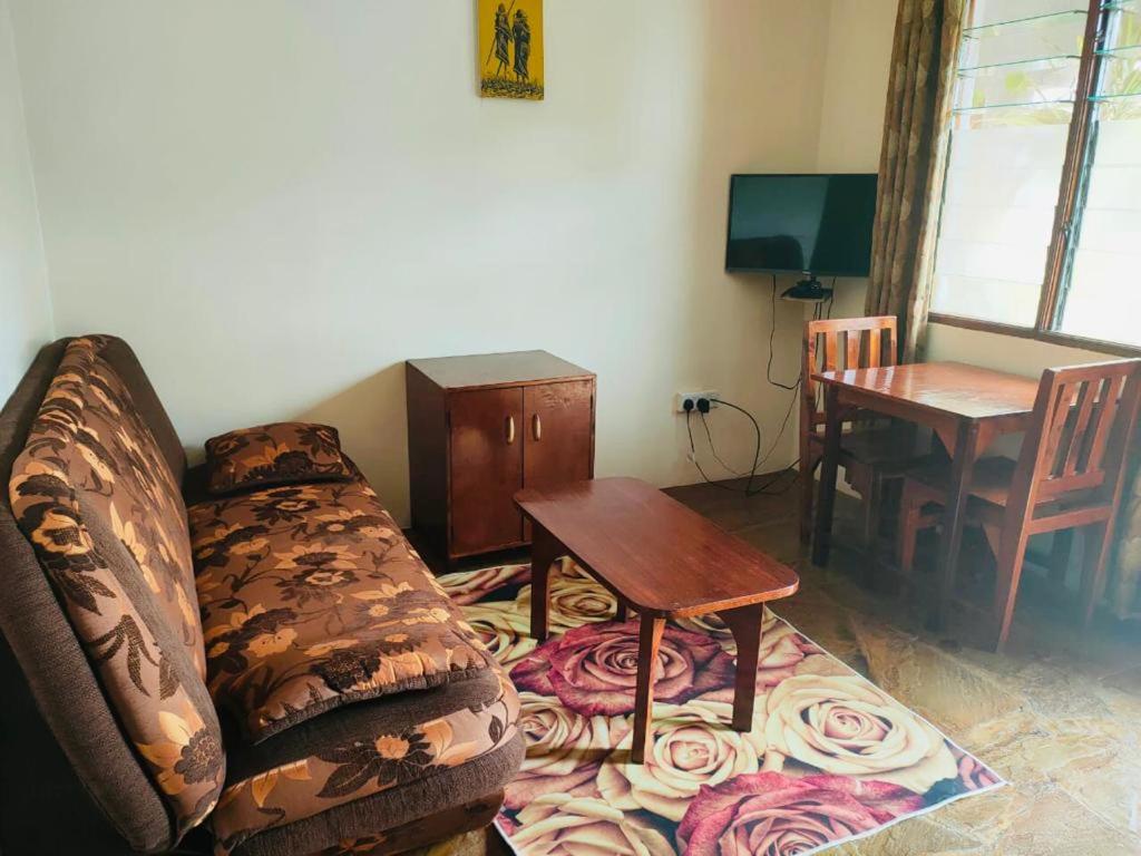 una sala de estar con un sofá y una mesa en Sea Breeze Apartments Shanzu Mombasa, en Mombasa