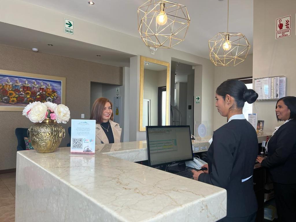 a group of women standing at a reception counter at Cordillera Hotel in Huaraz