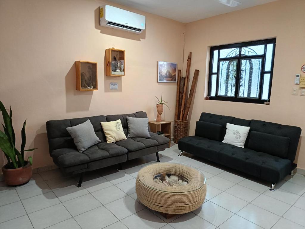 a living room with two couches and a table at Downtown Apartment One Block from the Ocean - Casa Aluxes in Cozumel
