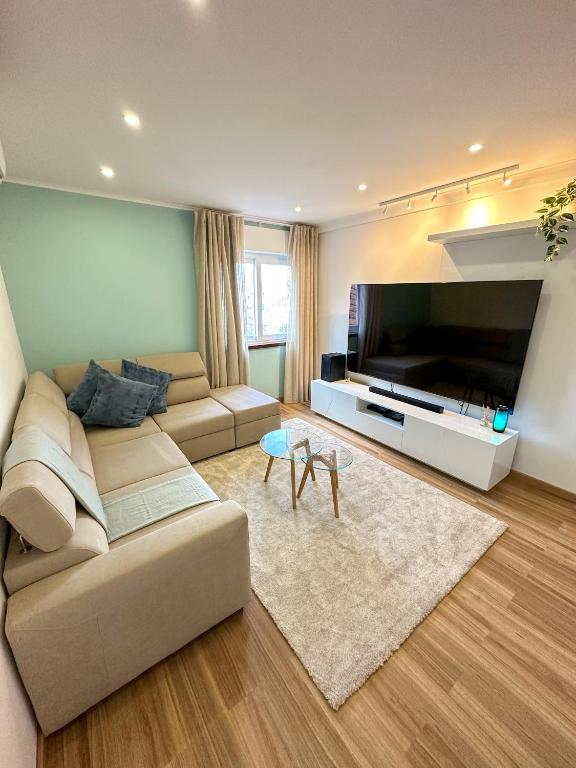 a living room with a couch and a large television at Lisbon Luxury Studio in Amadora