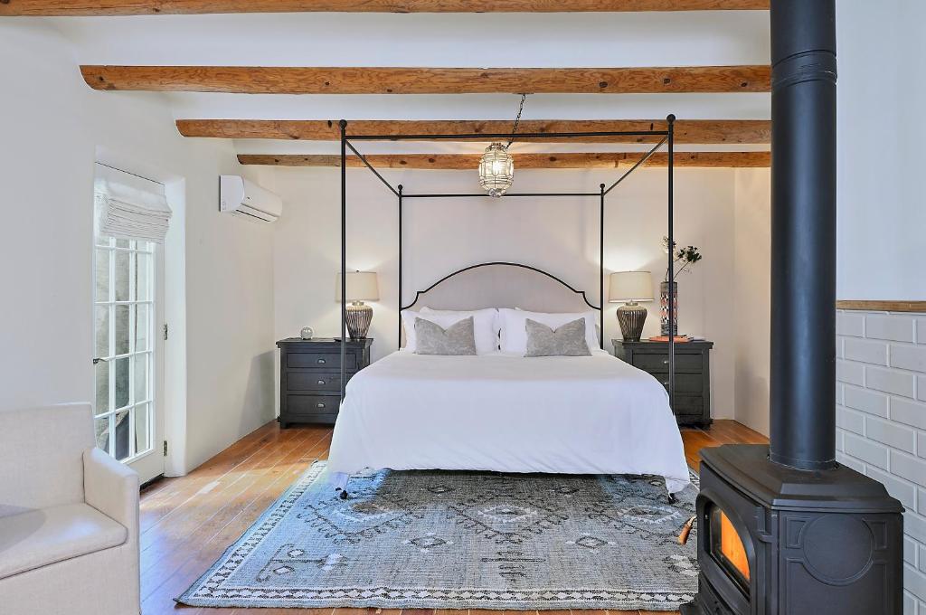 a bedroom with a bed and a wood stove at Dos Hermanas Casita 6 Downtown Courtyard Patio in Santa Fe