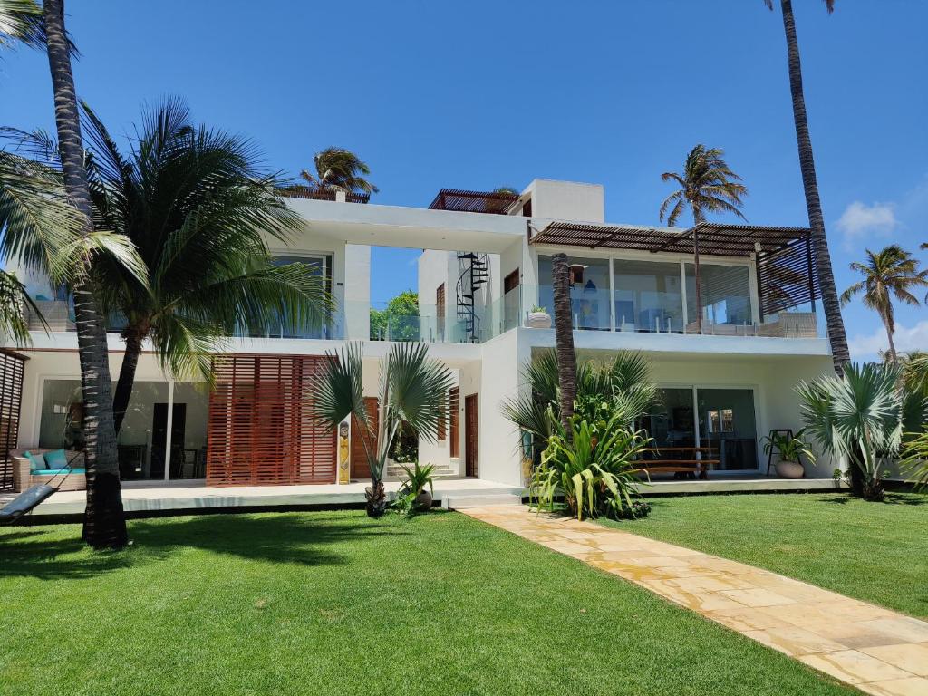 a house with palm trees in front of it at BEACH VILLA Camurupim in Guajiru