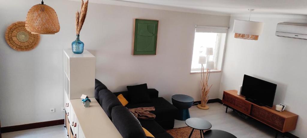 - un salon avec un canapé et une télévision dans l'établissement Sesimbra - Praia e Castelo, à Sesimbra