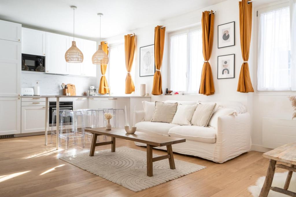 a white living room with a white couch and a table at Beautiful duplex on the outskirts of Paris - Welkeys in Levallois-Perret
