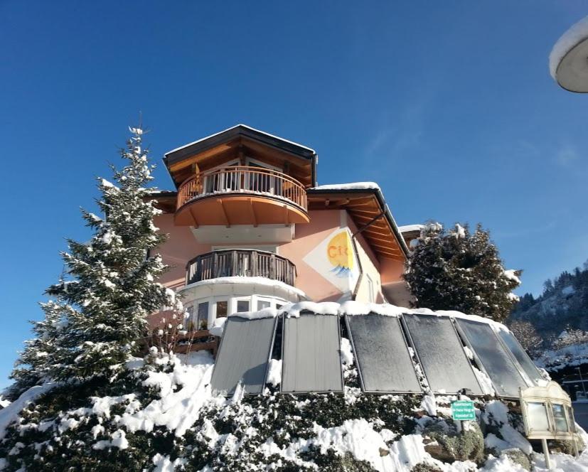 un bâtiment avec un arbre de Noël dans la neige dans l'établissement Appartement Gern, à Alpendorf