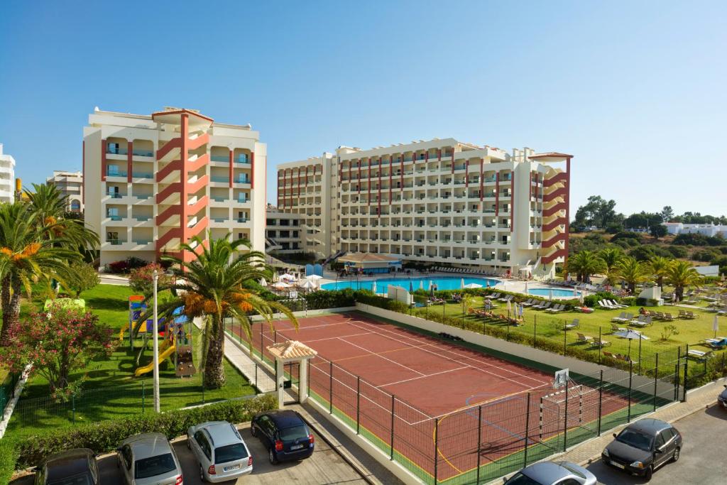 una pista de tenis en un aparcamiento con edificios en Ukino Palmeiras Village - 24h All Inclusive, en Armação de Pêra